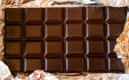 A bar of dark chocolate seen from the top. It is surrounded by gold wrapping foil.