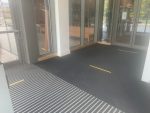 Yellow tape on door mat marks social distancing queue points