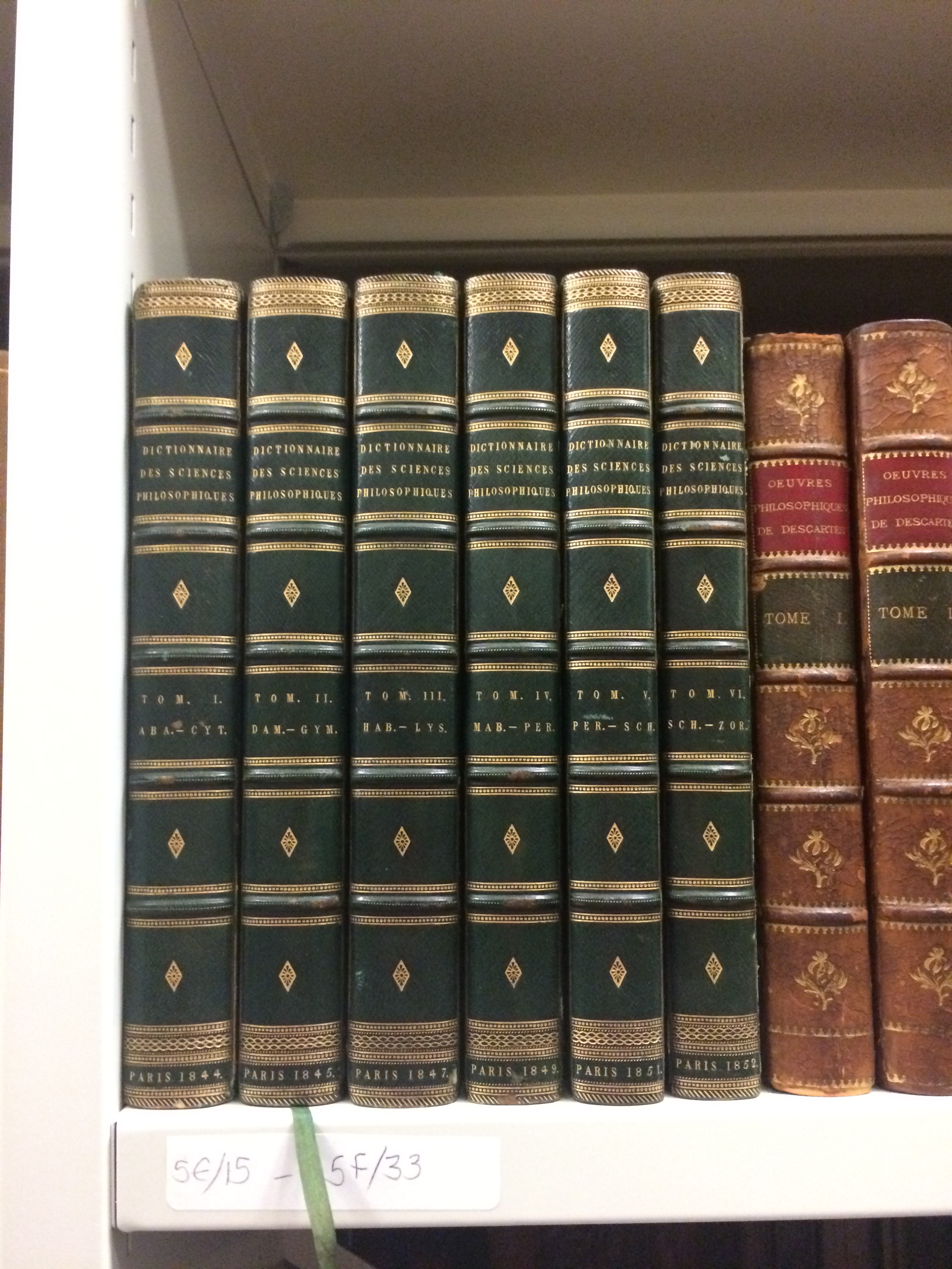 A collection of green books with guilded gold decoration.