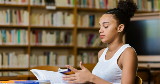 Black woman studying at desk in library