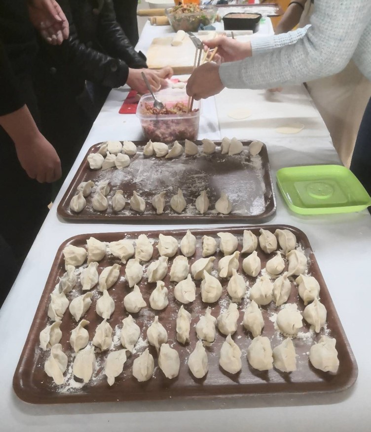 An image of friends making dumplings (Jiaozi) together on Chinese New Year