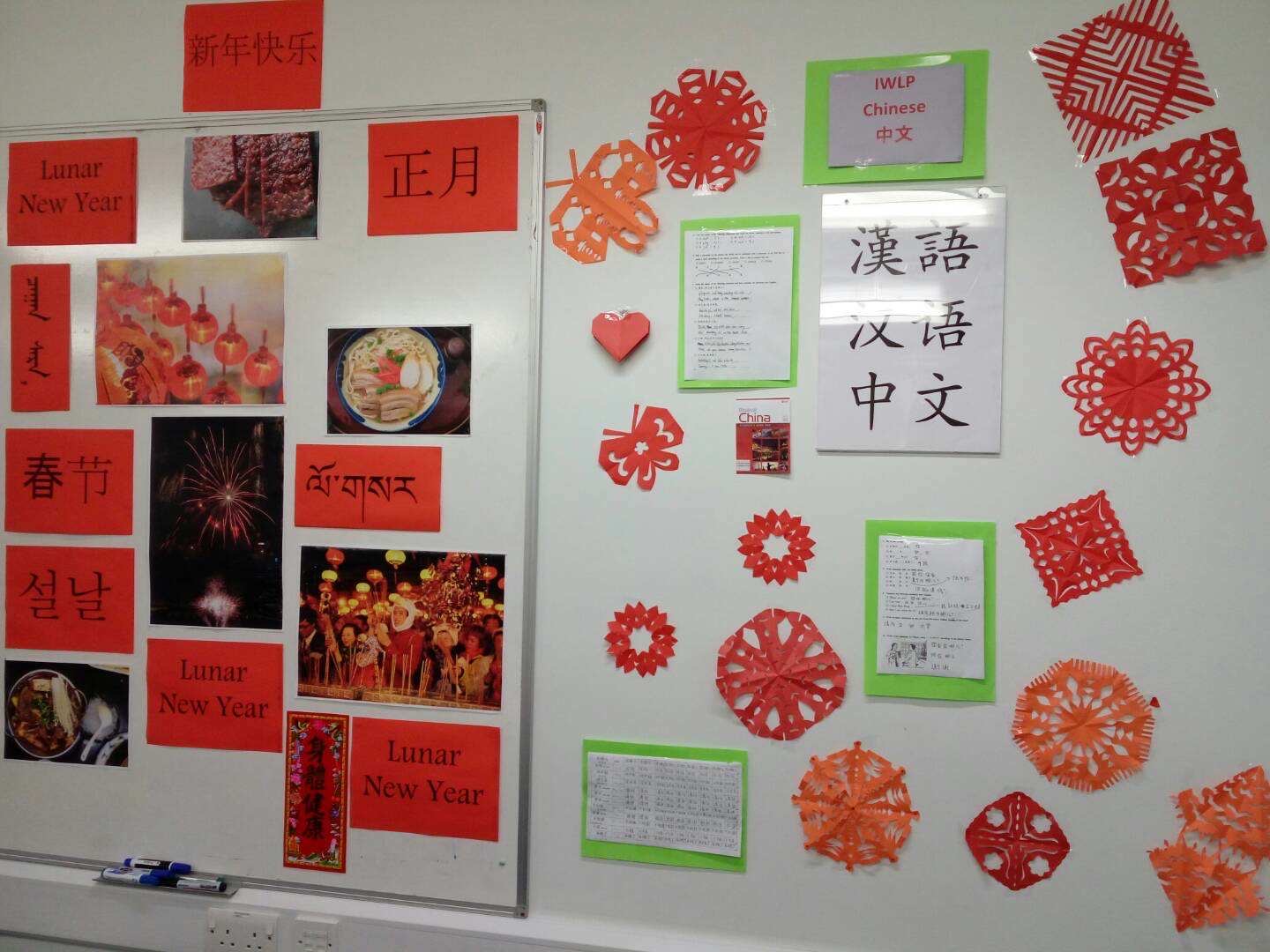 A photograph of a variety of items made during activities for Chinese New Year, including paper cutting and calligraphy