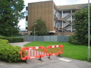 Orange barrier across footpath with partially demolished Library building behind