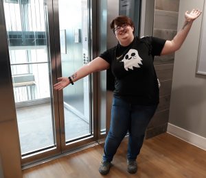 Person holding out arms to display new glass lift behind