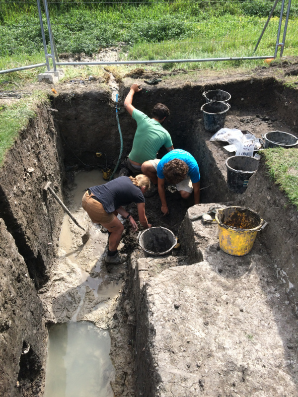 Heather, Tom and Alex excavate in very tricky conditions below the water table, using a pump to keep the trench from filling with water
