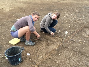 Jacoline and Gabija clear the edge of the flint area by hand to reveal a metalled surface