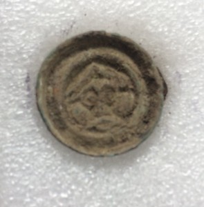 The button brooch, only about 1.5cm in diameter. You can see a stylised face, and perhaps a moustache too!