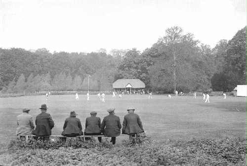 This photograph, taken by Eric Guy during the late 1930s, shows a cricket match in progress. A group of villagers follow the score from the edge of the pitch (MERL P DX289 PH1/4393)