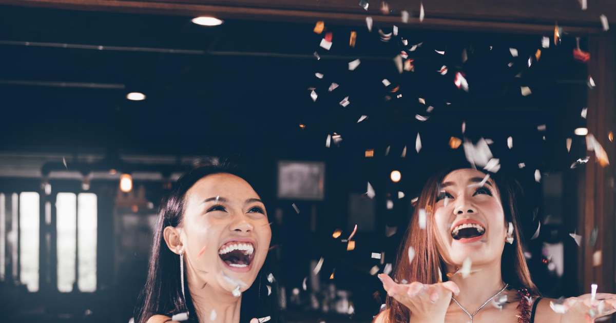 photography of Asian young women celebrating, confetti in the air.