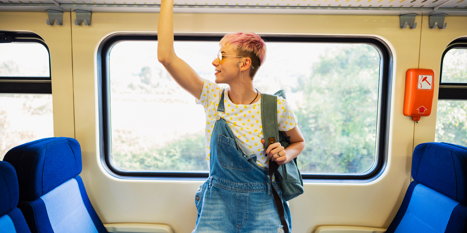 A girl on a train holding the rail above