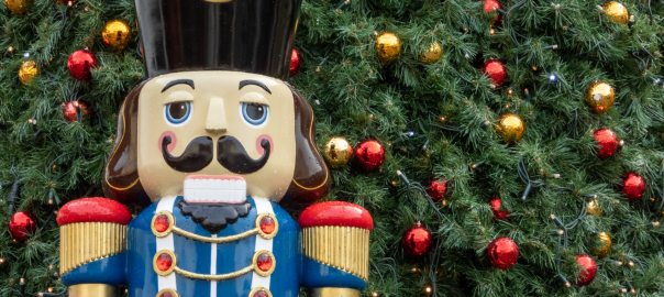 Large nutcracker in front of a Christmas Tree
