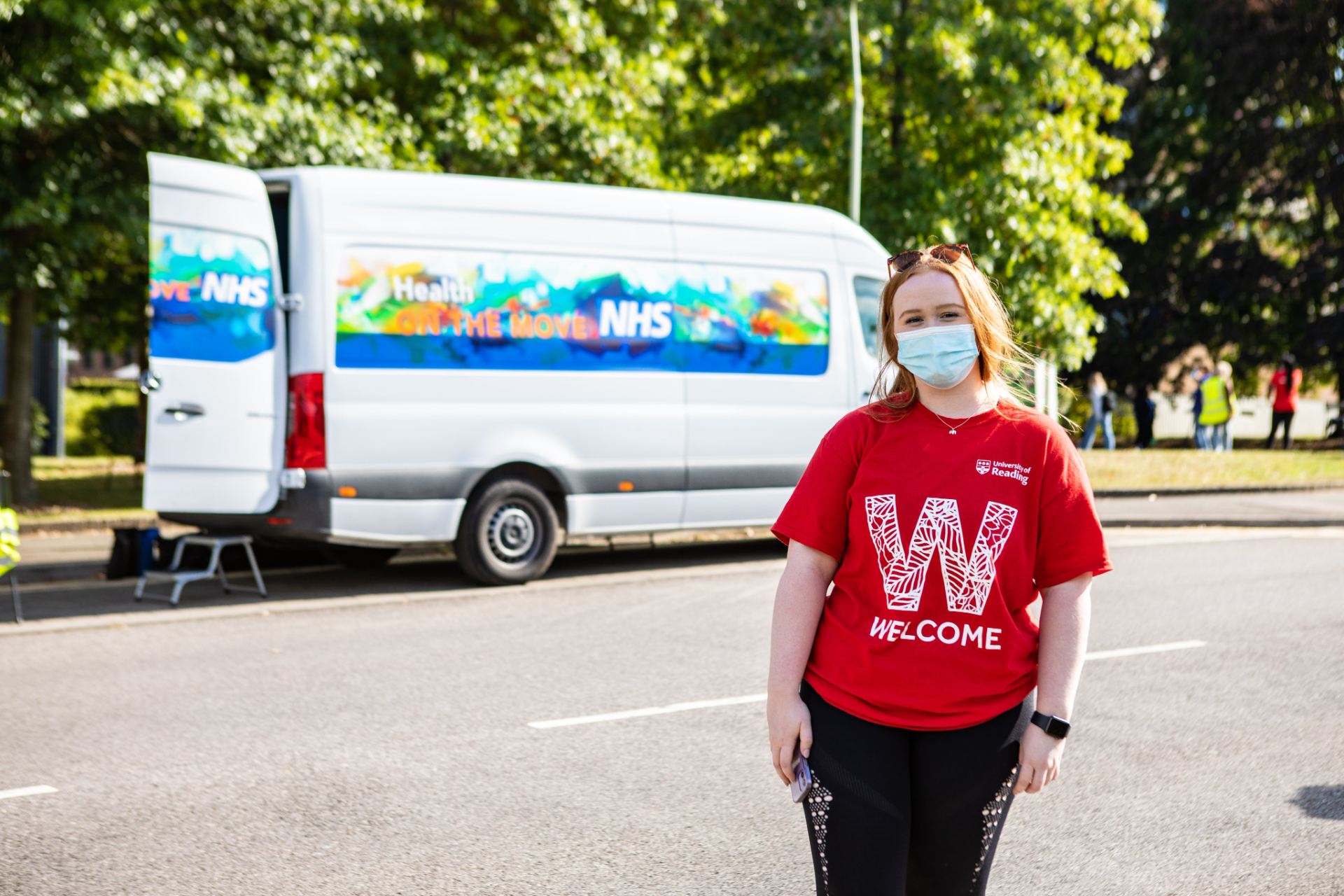 Image shows a Reading student outside a vaccine van