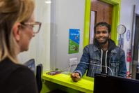 A student collecting documents from the Carrington Reception in the Student Services building.