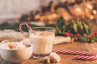 Festive image with winter drinks, fairy lights, candy canes